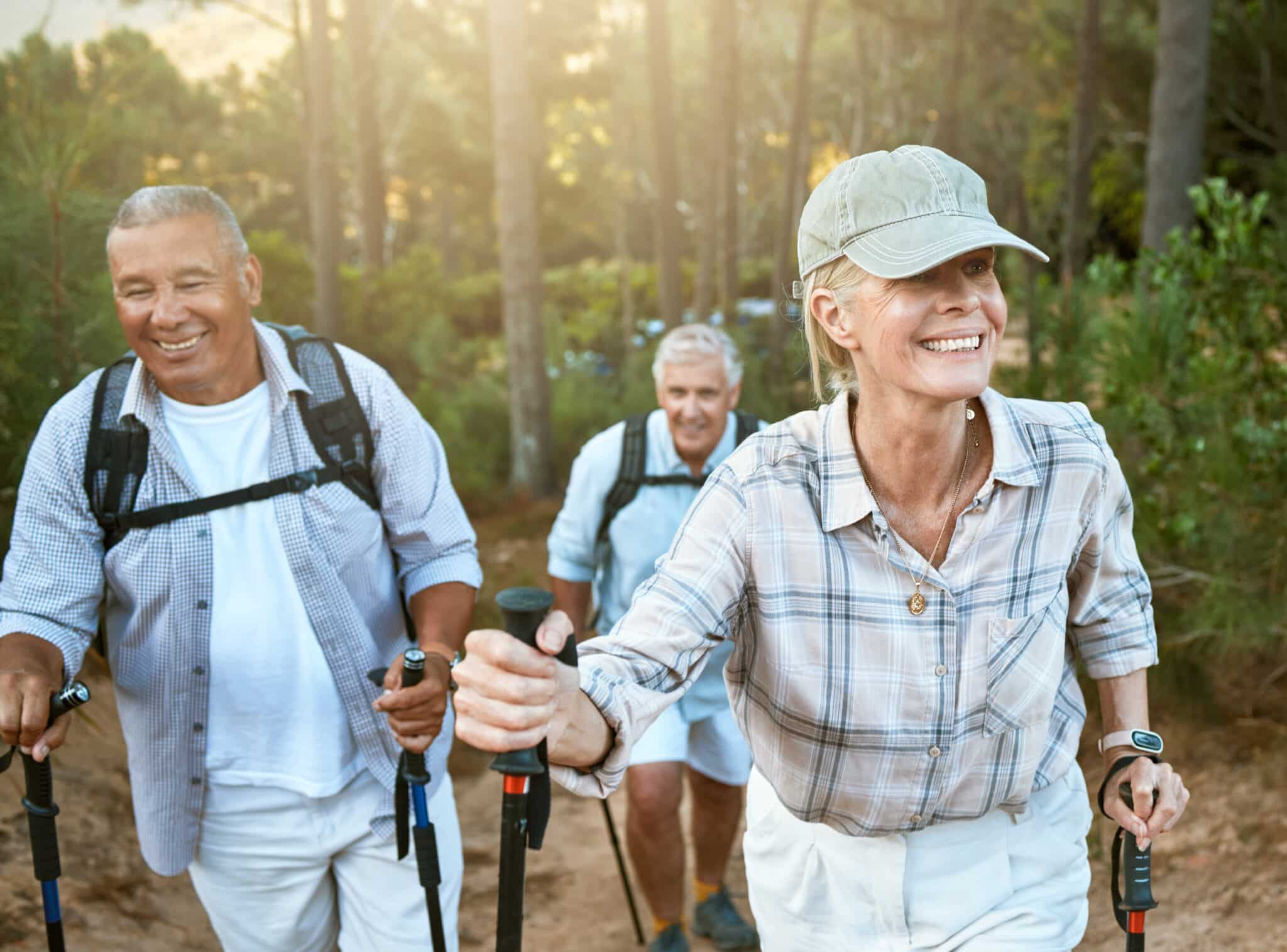 Hiking retired, elderly and senior friends or tourists in forest or mountains for fitness, health a